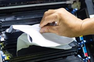 técnicos removendo papel preso, atolamento de papel na impressora no escritório foto