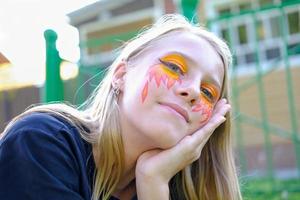 linda garota adolescente com pintura de rosto. foto