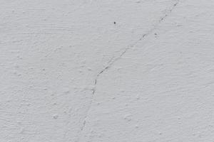 textura de uma parede de concreto com rachaduras e arranhões que podem ser usados como pano de fundo foto