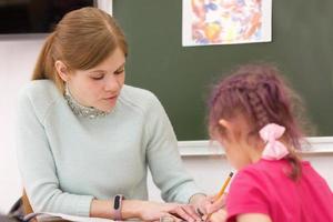 professor de arte ajudando aluno pré-escolar na aula de arte. foto