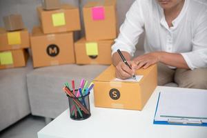 mão de empresário escrevendo em caixas de encomendas foto