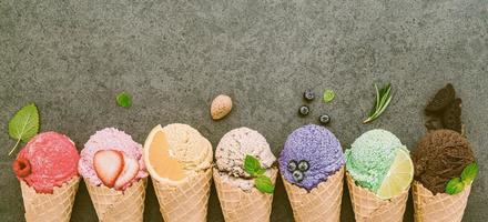 plana leigos coleção de cones de sorvete em fundo de pedra escura. em branco casquinha de sorvete crocante com espaço de cópia para o design do menu de doces. foto