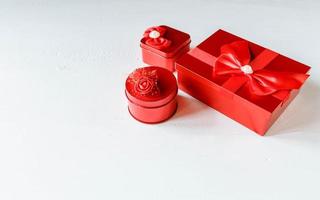 caixa de presente vermelha sobre fundo branco de madeira foto