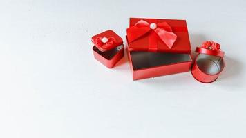 caixa de presente vermelha aberta na mesa de madeira branca foto