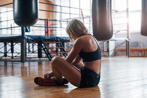 aguardando a recuperação da resistência. cansado após o treino. descansando na academia para treinamento esportivo de caixa foto