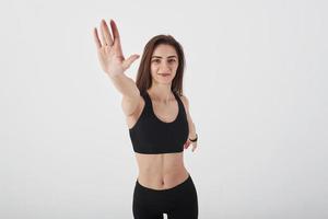 dando mais cinco. jovem mulher bonita no estúdio em pé contra um fundo branco foto