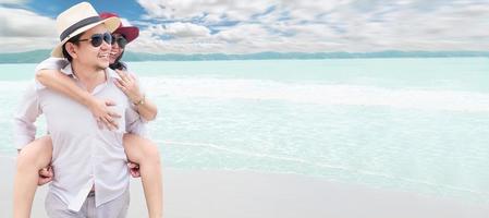 casal asiático feliz lua de mel na praia do mar foto