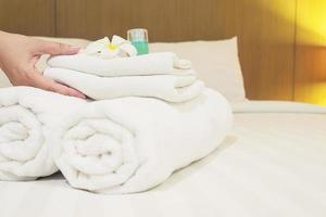 senhora montou toalha branca na cama no quarto de hotel foto