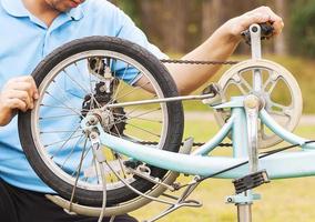 homem está consertando bicicleta. foto é focada em uma roda.