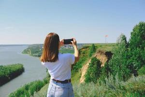 linda mulher tirando uma foto de uma paisagem