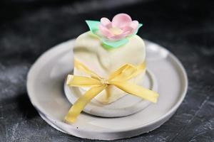 mini bolo decorado com flores comestíveis e folhas feitas de papel de arroz. doce deleite para a selebração de halloween de outono, decoração de fita. cobertura de gelo. foto