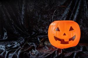 feliz balde de abóbora de halloween em veludo preto com espaço de cópia foto