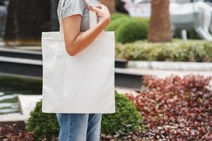 mulher hipster com saco de algodão branco no parque foto