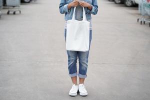 mulher hipster com saco de algodão branco no parque foto