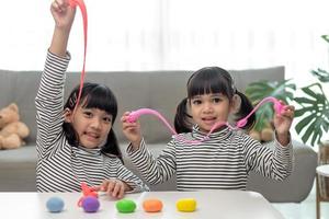 a menina está aprendendo a usar massinha colorida em uma sala bem iluminada foto