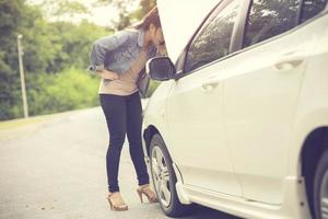 mulheres especulam que ela abriu o capô do carro quebrado na lateral ver motores que estão danificados ou não.cor vintage foto