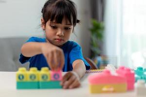 menina criança asiática jogando blocos de brinquedo criativos para homeschooling foto