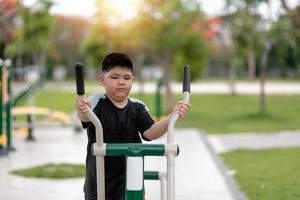 gordo treina em equipamentos de ginástica no parque foto