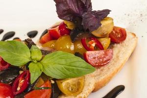 tomates suculentos no pão fresco, pesto como cobertura foto