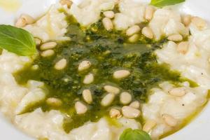 foto de delicioso prato de risoto com ervas e noz de cedro em fundo branco