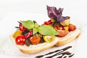 tomates suculentos no pão fresco, pesto como cobertura foto