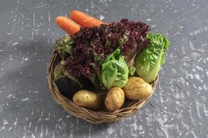 comida saudável vegetal alface vermelha e batata de cenoura berinjela romana na mesa de madeira cinza, vista superior, copie o espaço. foto