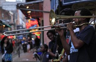 12 de abril de 2017 - new orleans, louisiana - músicos de jazz tocando no bairro francês de new orleans, louisiana, com multidões e luzes de neon ao fundo. foto