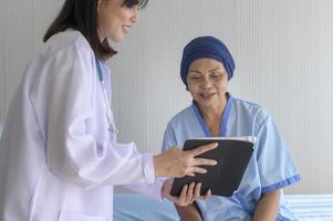 mulher paciente com câncer usando lenço na cabeça após consulta de quimioterapia e médico visitante no hospital.. foto