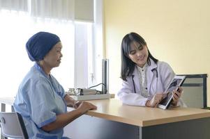 mulher paciente com câncer usando lenço na cabeça após consulta de quimioterapia e médico visitante no hospital.. foto