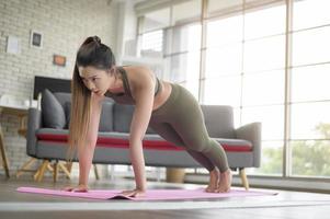 mulher jovem fitness em roupas esportivas se exercitando em casa, saudável e estilos de vida. foto