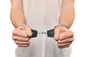 mãos de criminoso algemado, prisão de criminoso perigoso, violação da lei, fundo branco foto