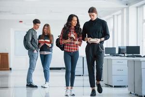 quais nossos planos hoje. grupo de jovens andando no escritório na hora do intervalo foto