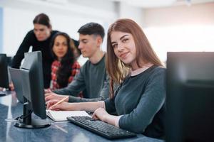 bela menina. grupo de jovens em roupas casuais trabalhando no escritório moderno foto