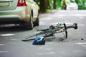 bicicleta e acidente de carro prateado na estrada na floresta durante o dia foto