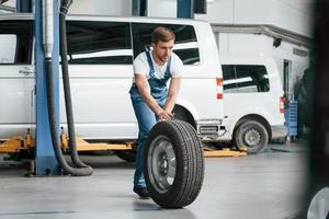 volto logo. funcionário de uniforme de cor azul trabalha no salão de automóveis foto