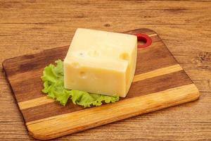 queijo emmental sobre tábua de madeira foto