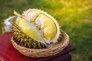 durian maduro e fresco, casca de durian com cor amarela na mesa de madeira. foto