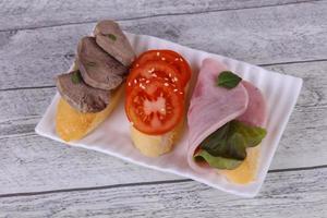 bruschetta com tomate, presunto e língua foto