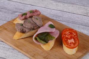 bruschetta com tomate, presunto e língua foto