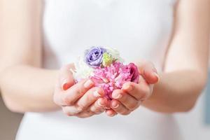 flores frescas na mão da mulher. conceito de beleza e spa, cuidados de saúde. foto