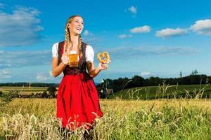 mulher com tracht, cerveja e pretzel na Baviera foto