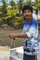 homem olhando para a câmera preparando sua rede para pesca. foto