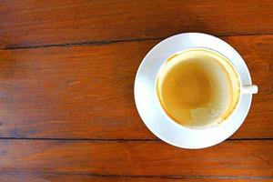 xícara vazia branca de café cappuccino na mesa de madeira, vista superior. foto