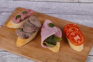 bruschetta com tomate, presunto e língua foto