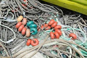 rede de pesca usada com pvc colorido flutua fora da água para reparo. fundo foto