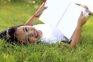 menina asiática relaxar e ler um livro no parque foto