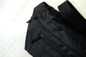 bolsa de cintura masculina negra em cima da mesa foto