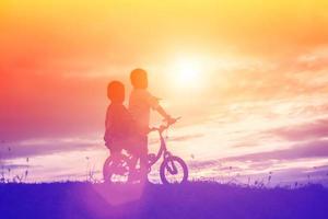 silhueta de bicicleta de dois meninos foto