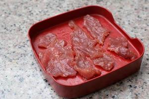 carne fresca crua fatiada foi servida para sukiyaki e shabu ou restaurante yakiniku que pôs em um prato vermelho. foto