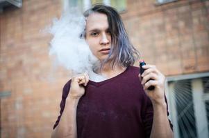 retrato de um jovem na fumaça de cigarros foto